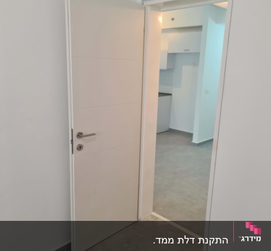 דלת פתוחה עם ידית מתכת בחדר פנימי